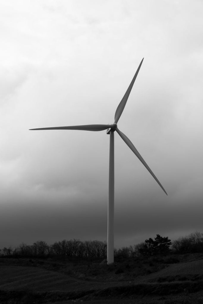 pexels-photo-29449324 A towering wind turbine against a dramatic cloudy sky in the countryside.